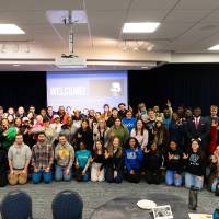 large group of several rows of people posing for photo
